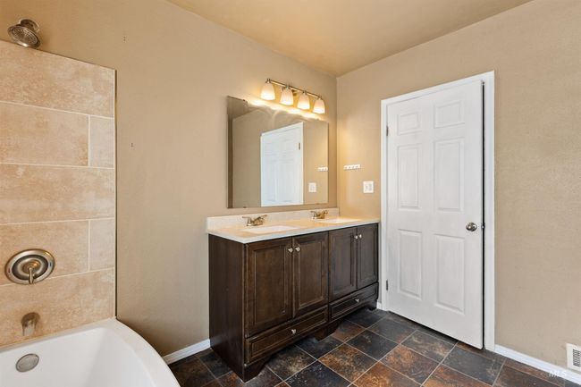 Bathroom featuring double vanity and dark stone finish floors | Image 26