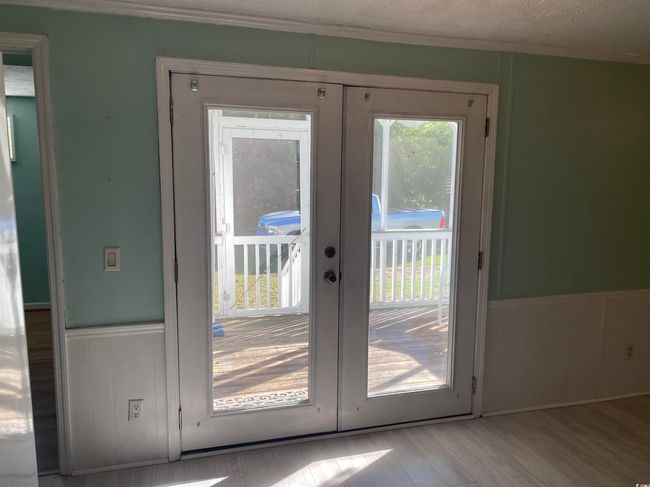 Entryway featuring french doors, ornamental molding, wood finished floors, a wainscoted wall, and a decorative wall | Image 14
