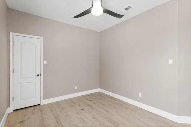Empty room with light wood-style floors and ceiling fan | Image 18