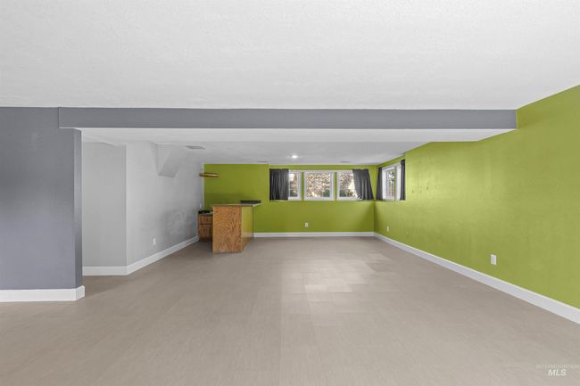 Unfurnished living room with baseboards and bar | Image 33