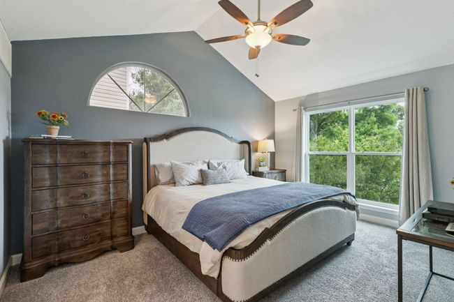 Carpeted bedroom with vaulted ceiling, multiple windows, a ceiling fan, and baseboards | Image 17