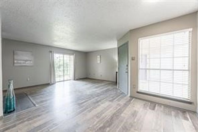 Unfurnished living room with wood finished floors and a textured ceiling | Image 6