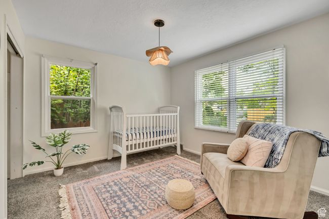 Carpeted bedroom with multiple windows and a crib | Image 8