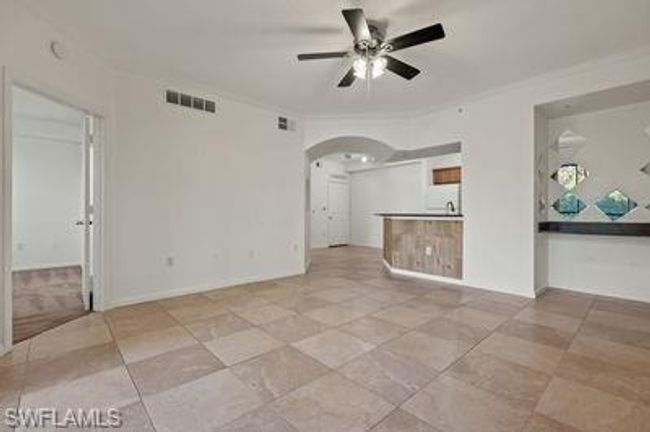Unfurnished living room with visible vents, ceiling fan, and arched walkways | Image 9