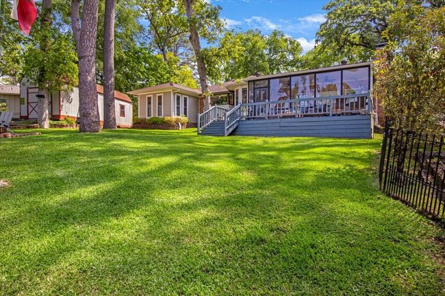Back of house with fence, stairs, a deck, a lawn, and a sunroom | Image 28