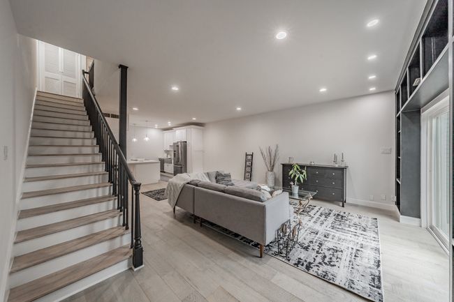 Living room with stairway, baseboards, recessed lighting, and light wood-style flooring | Image 9