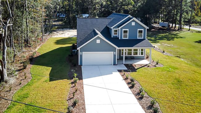 View of front of house featuring a garage, a front lawn, and covered porch | Image 21