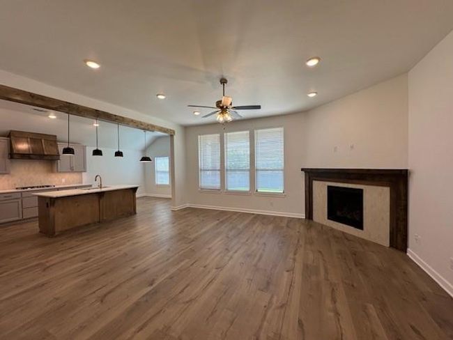 Unfurnished living room featuring dark wood finished floors, recessed lighting, ceiling fan, a high end fireplace, and baseboards | Image 4