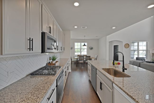 Kitchen featuring a sink, recessed lighting, stainless steel appliances, arched walkways, and dark wood-type flooring | Image 14