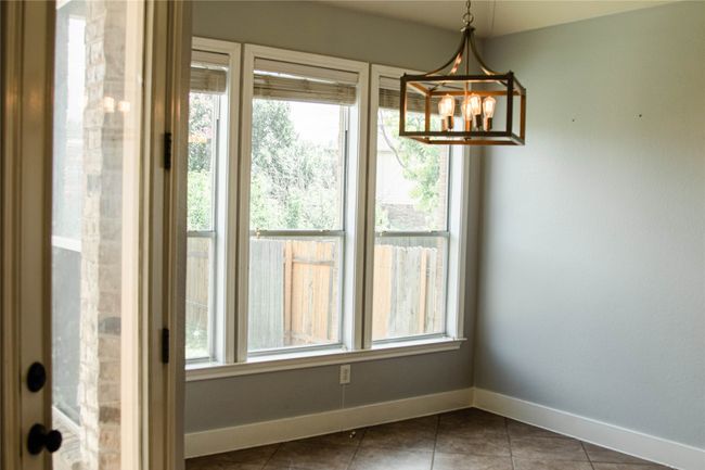 Unfurnished dining area featuring tile patterned floors and a chandelier | Image 13