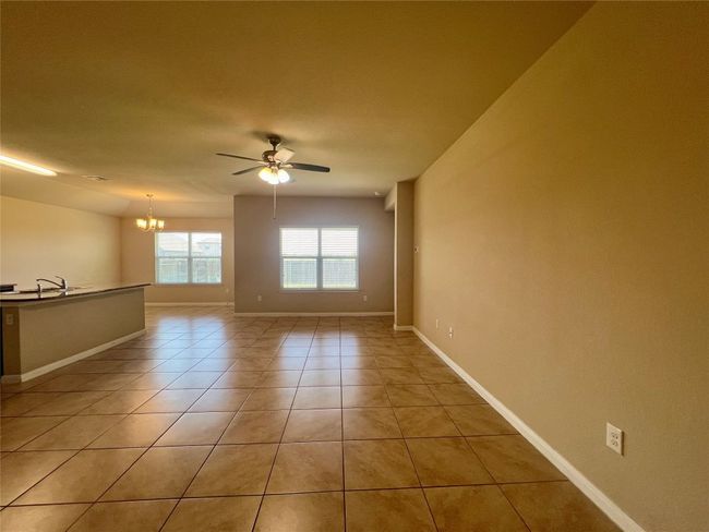 Family room featuring a chandelier, a ceiling fan, light tile patterned floors, and baseboards | Image 20