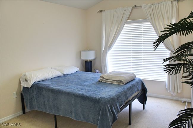 Bedroom with lofted ceiling, carpet flooring, and baseboards | Image 19