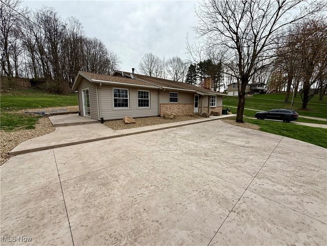 View of front of property featuring a chimney, a front lawn, and concrete driveway | Image 10