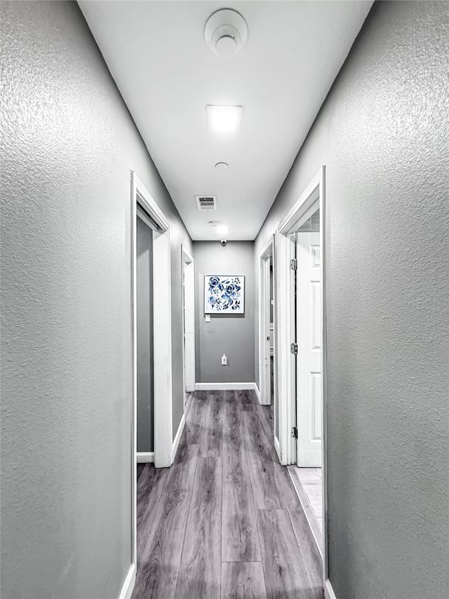 Hallway featuring a textured wall and wood finished floors | Image 27