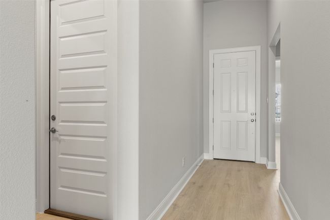 Hallway featuring light wood finished floors and baseboards | Image 9
