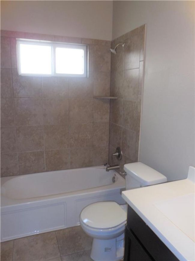 Bathroom featuring vanity, tile patterned floors, tub / shower combination, and toilet | Image 15