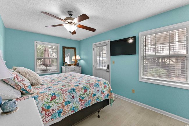 Bedroom with wood finished floors, baseboards, a textured ceiling, and a ceiling fan | Image 14