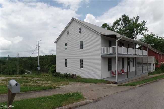 View of property exterior featuring covered porch and a balcony | Image 5