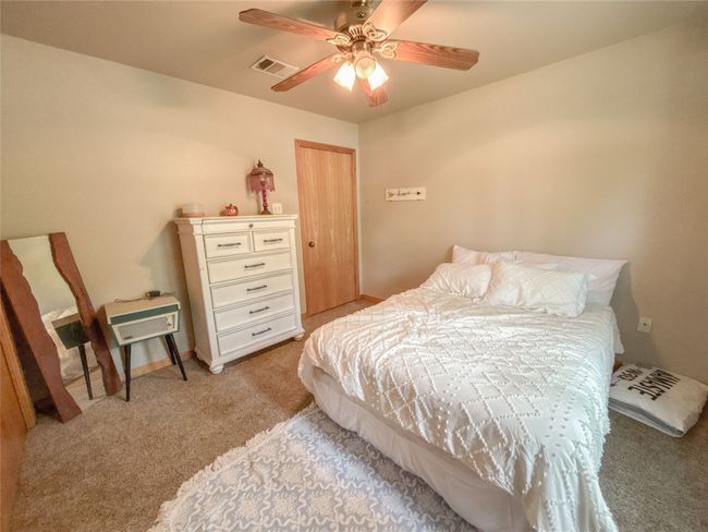 Bedroom with light colored carpet, visible vents, a ceiling fan, and a closet | Image 19