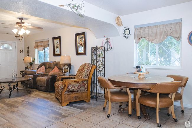 Dining space with a ceiling fan and light tile patterned floors | Image 5
