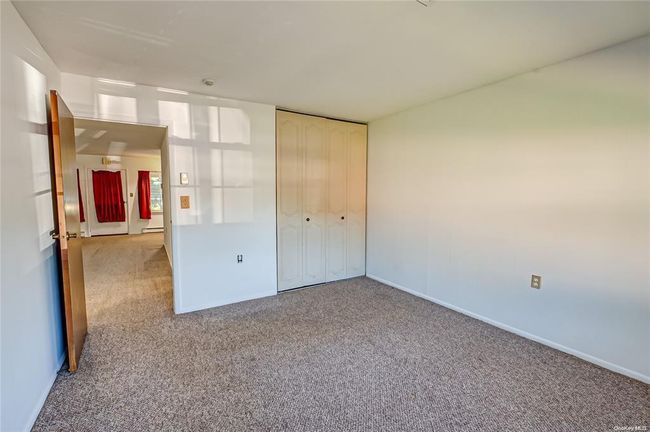 Unfurnished bedroom with light carpet and a closet | Image 6