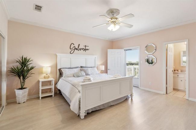This spacious and serene primary bedroom features soft, neutral tones and plenty of natural light, creating a relaxing retreat. A private deck offers an ideal spot to enjoy quiet mornings or take in the evening breeze. The room includes an en-suite bathroom for added convenience and mirrored closet doors that enhance the sense of space. With its elegant design and thoughtful layout, this primary bedroom is perfect for unwinding in comfort. | Image 13