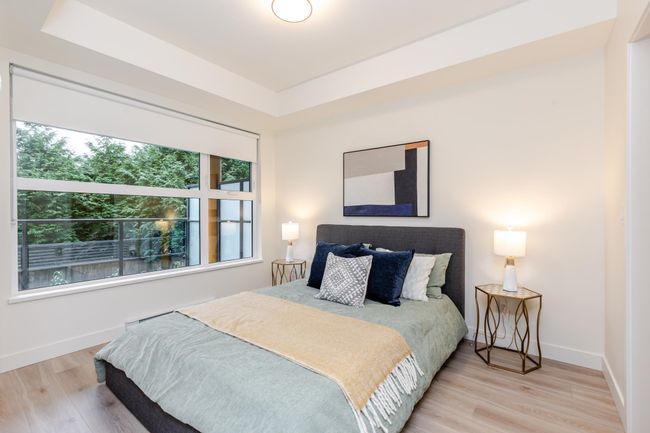 Bedroom with a raised ceiling and wood finished floors | Image 12