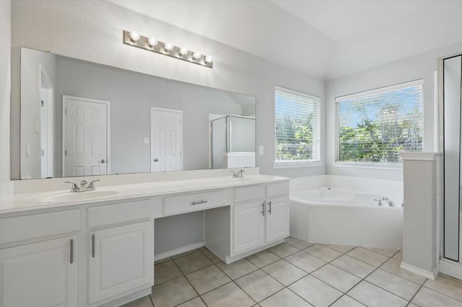 Bathroom featuring double vanity, a bath, a shower stall, and tile patterned floors | Image 19