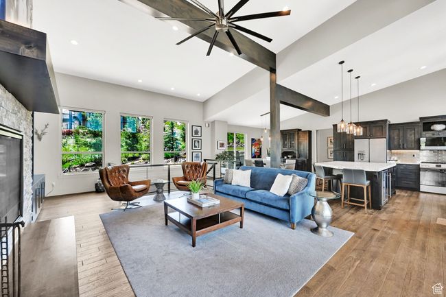 Living area with recessed lighting, light wood finished floors, high vaulted ceiling, a chandelier, and a glass covered fireplace | Image 17
