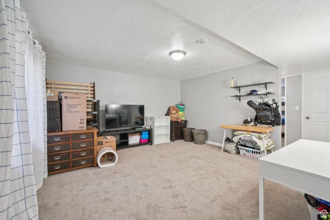 Carpeted living area featuring a textured ceiling | Image 17