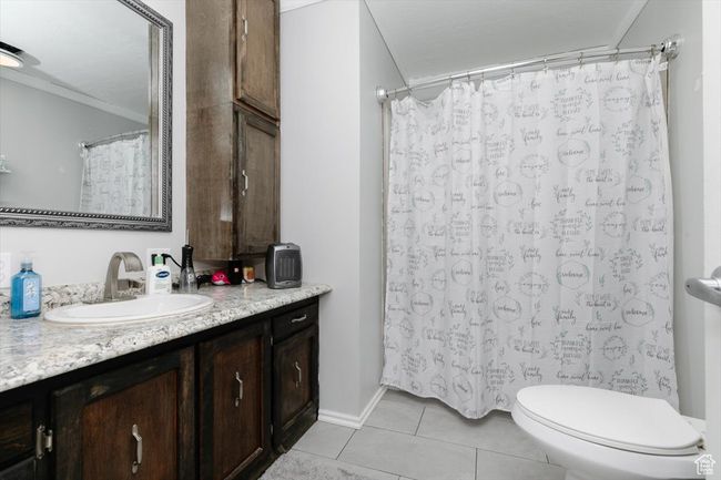 Bathroom featuring a shower with shower curtain, vanity, tile patterned floors, crown molding, and toilet | Image 25