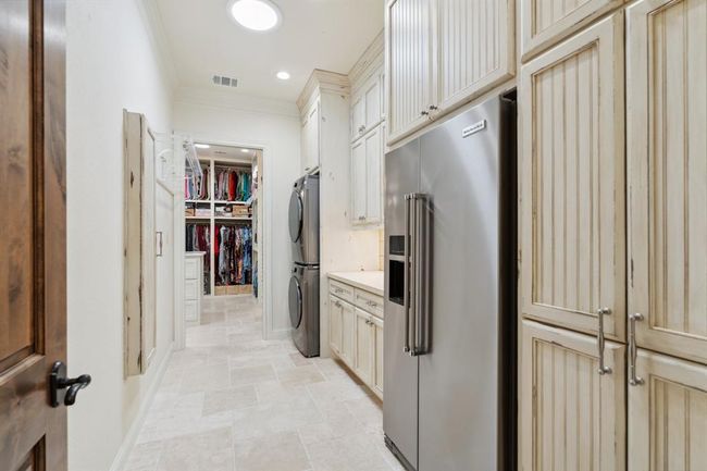 The Laundry/Utility Room features custom-designed andcreated floor-to-ceiling faux-finished cabinets.Another well-designed convenience is thebuilt-in retractable Premium "Iron-A-Way" ironing center, witha swivel ironing board, an interior light, an electrical outlet, andstorage. | Image 28