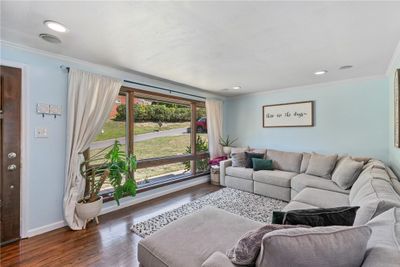 Sun drenched living room boasts large picture window, recessed lighting and crown molding. | Image 2