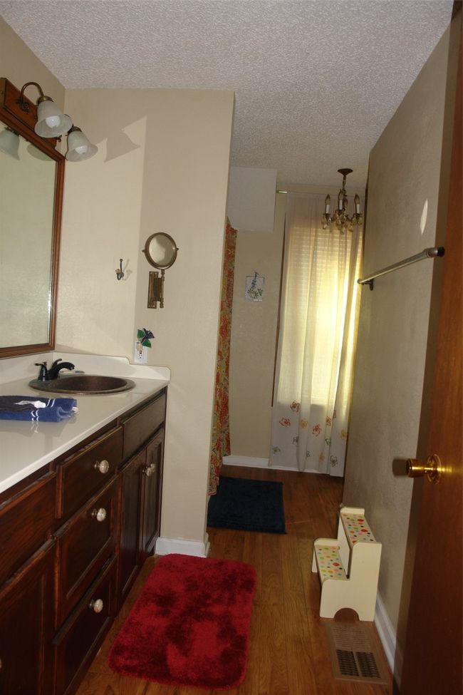 Bathroom with hardwood / wood-style flooring, vanity, a textured ceiling, and a notable chandelier | Image 11