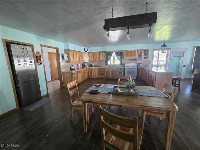 Dining room with dark wood finished floors, baseboards, and a textured ceiling | Image 31