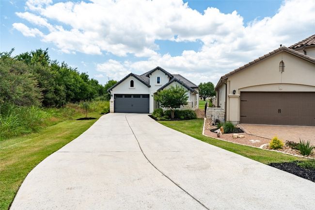 View of front of home with a front lawn, driveway, stucco siding, and an attached garage | Image 5