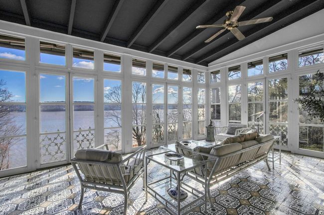 Sunroom featuring ceiling fan, a water view, and vaulted ceiling with beams | Image 13
