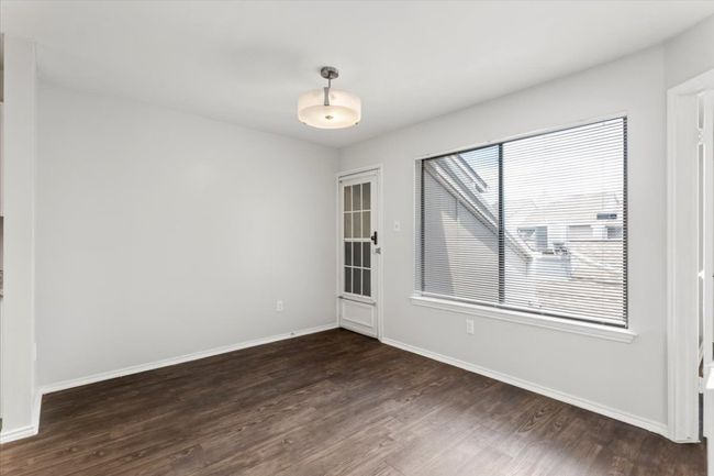 Large window in dining room allows for natural light, stairway down to private garage | Image 10