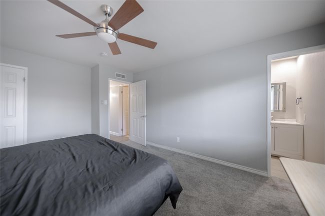 Bedroom featuring light carpet, ensuite bathroom, and ceiling fan | Image 23