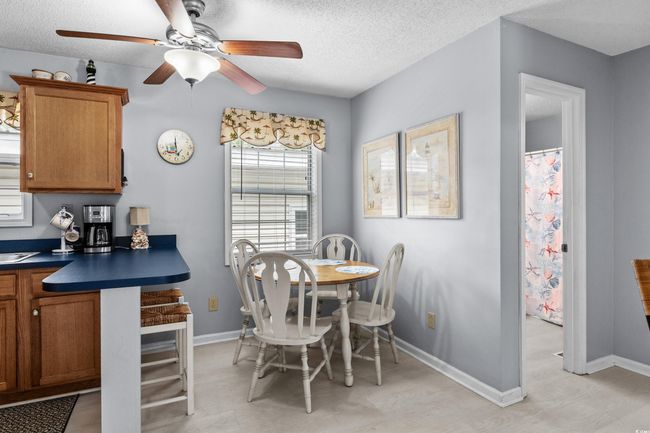 Dining area with a ceiling fan, baseboards, a textured ceiling, and light floors | Image 8