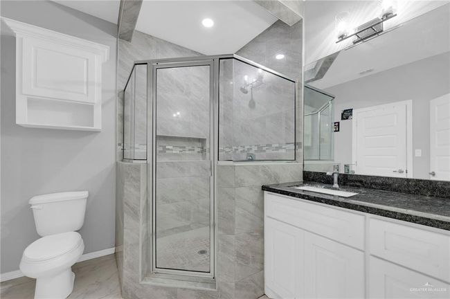 Full bathroom featuring marble finish flooring, vanity, a shower stall, and recessed lighting | Image 17
