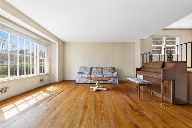 Living room featuring visible vents, wood finished floors, stairway, and a healthy amount of sunlight | Image 5