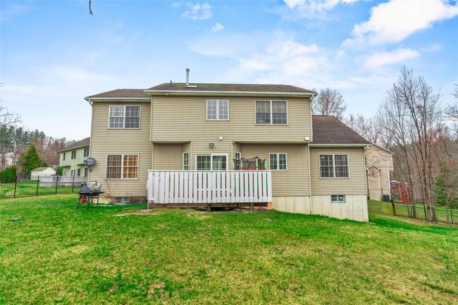 Rear view of house with a lawn, fence, and a deck | Image 44