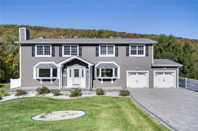 Colonial inspired home featuring a front lawn and a garage | Image 1