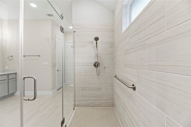 You'll enjoy long leisurely showers in the oversized walk-in shower with frameless glass, stunning tile work, a safety bar and bench seating. | Image 32