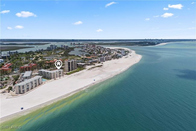From above, the endless shoreline of Fort Myers Beach stretches out, with soft sands, gentle waves, and the vibrant colors of the Gulf shining under the sun. | Image 4