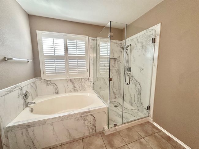 Full bathroom featuring a marble finish shower, a garden tub, and tile patterned flooring | Image 14