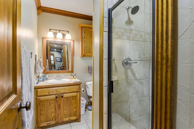 Bathroom with vanity, a stall shower, tile patterned flooring, and ornamental molding | Image 15