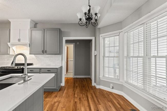 Kitchen featuring gray cabinets, light countertops, tasteful backsplash, baseboards, and a textured ceiling | Image 19