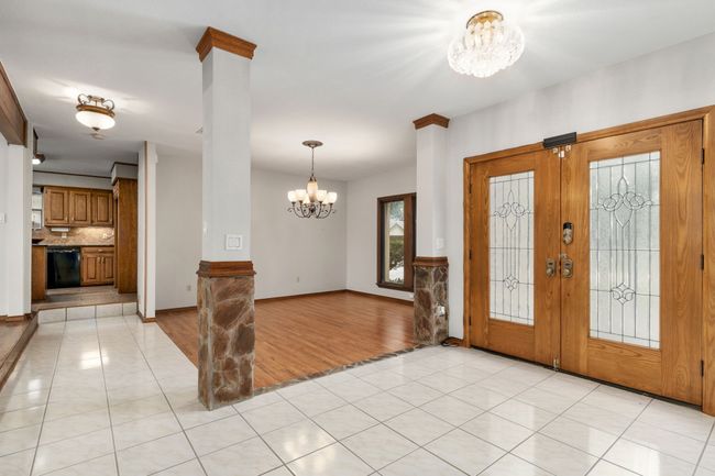 Entrance foyer with light tile patterned floors, french doors, a chandelier, and baseboards | Image 10